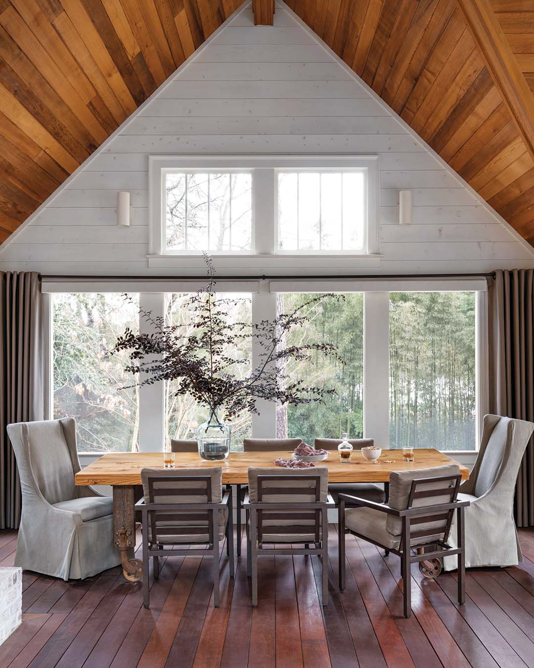 With rich, red-toned wood setting the stage, a custom farm table made by a neighbor is the perfect spot for lingering with friends and enjoying the Southern breeze.