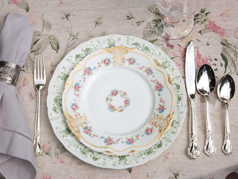 Dishware embellished with a delicate floral pattern adds a stylish yet sophisticated flair to the scene, complementing the lavender-toned napkins that line the table.