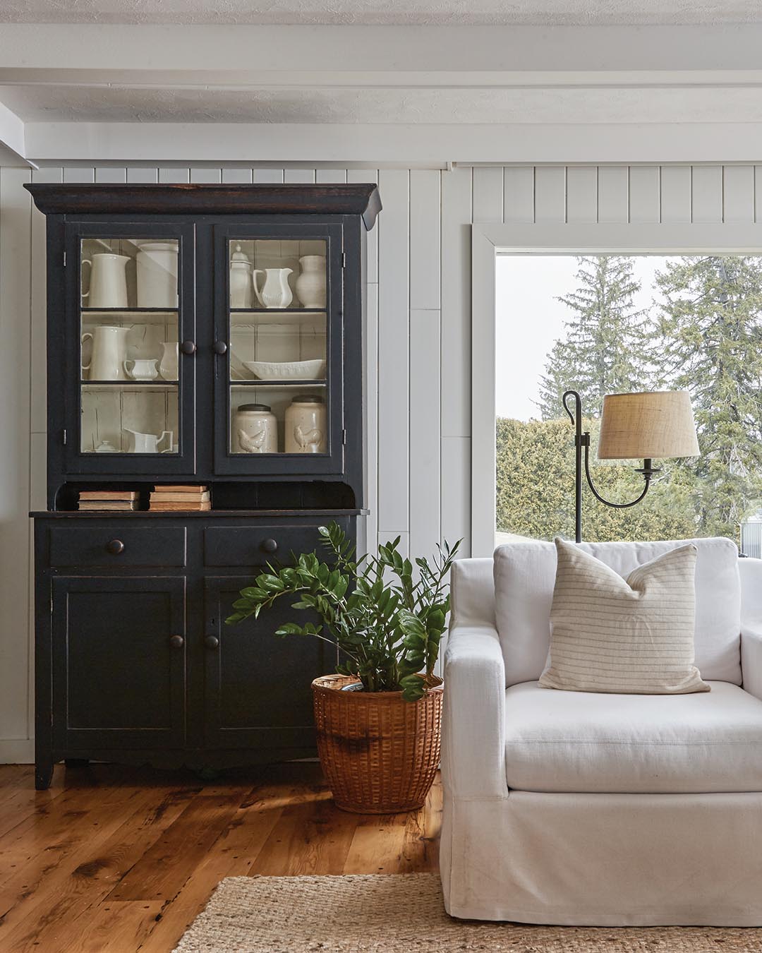 While most of the furnishings were brought in during the design process, there were a handful of antiques that already belonged to the clients—including a sleigh converted into a coffee table. A white armoire that now holds a grouping of glass jars is a family heirloom, as is the navy blue hutch that was painted to tie into the new kitchen palette.