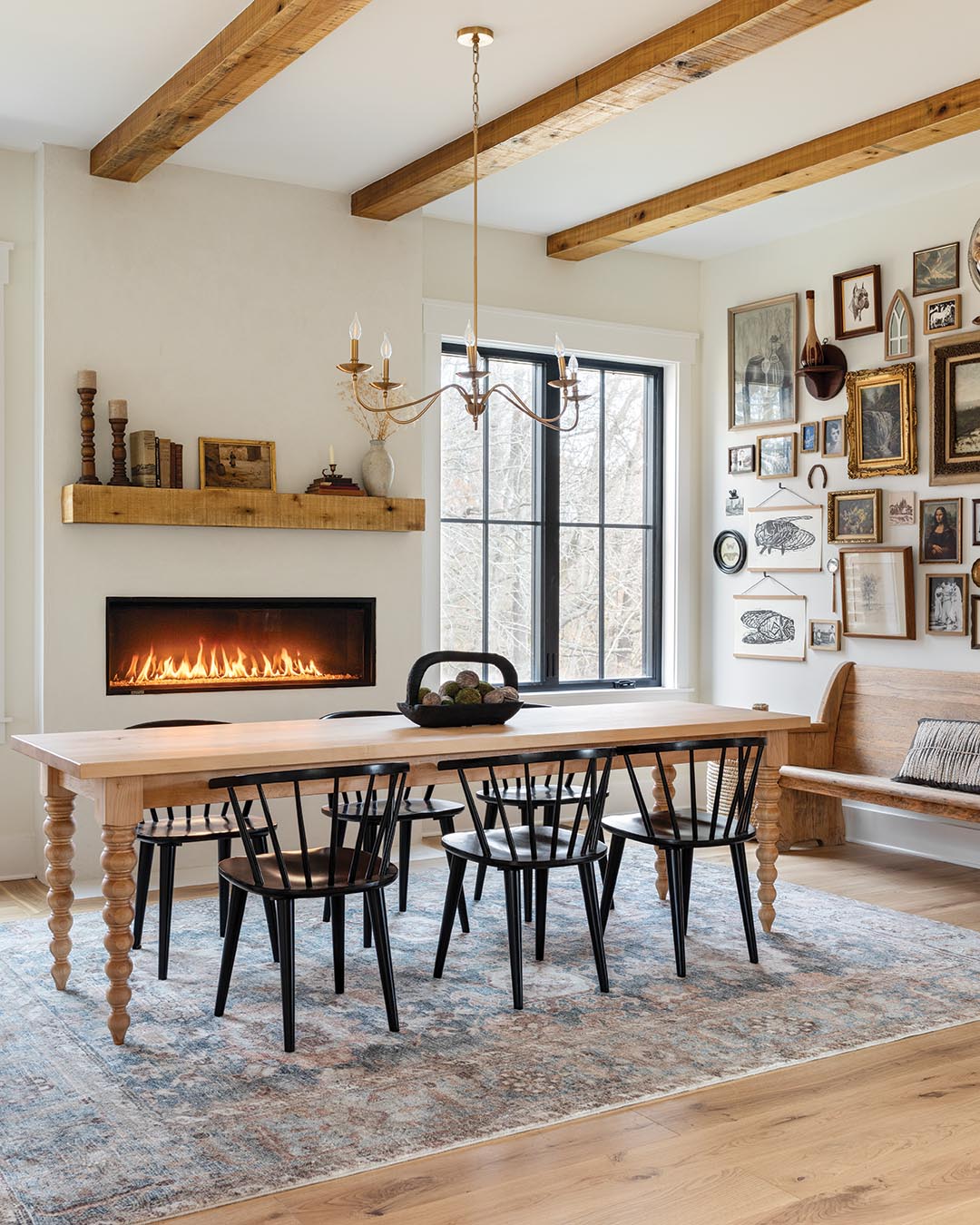 A sleek fireplace contributes warmth, having been intentionally raised to be at eye level for the family as they gather around a custom-made dining table.