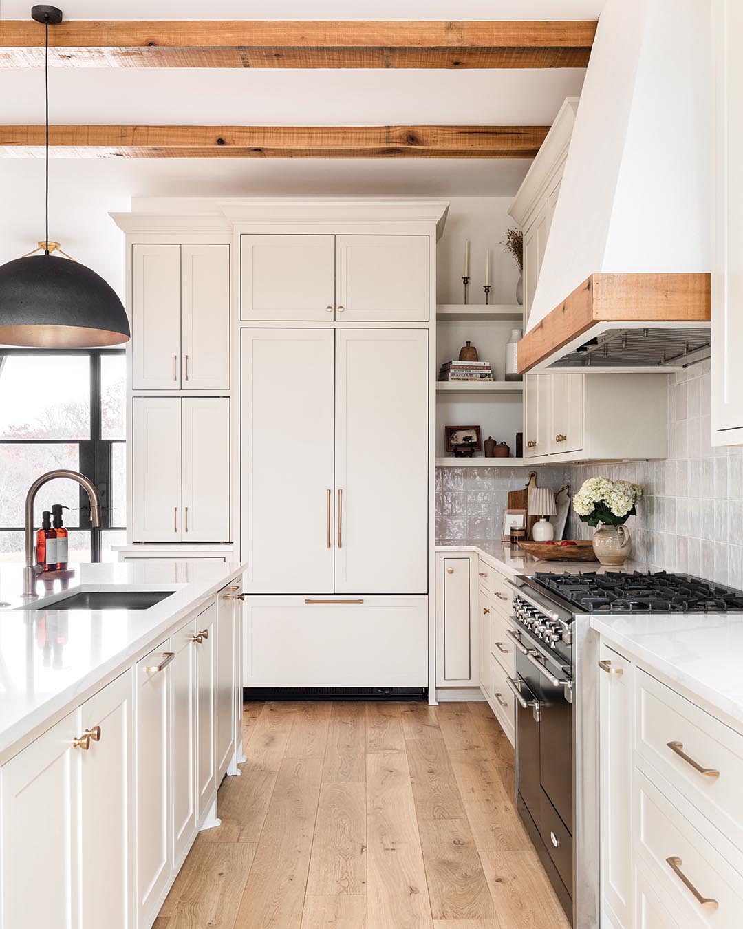 The square ceramic tiles of the backsplash contribute texture, and steel pendant lights in a dark finish add a contemporary touch.