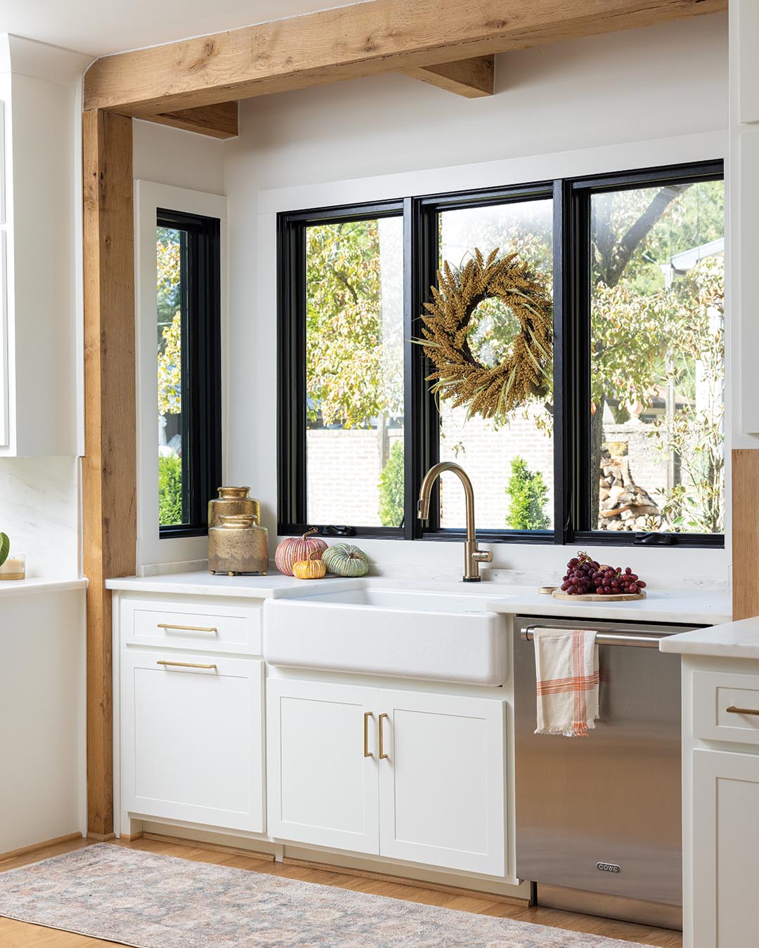 Inspired by an image she had seen in a design book, Lauri offset the kitchen sink area. Encased with natural beams, the nook doubles as a focal point as it warms up its all-white setting—with the bonus of additional space for windows to maximize sunlight.