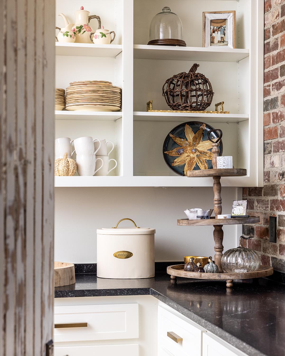 From the accent wall comprised of bricks reclaimed from the property’s former home to a pair of weathered antique doors salvaged from a historic hospital, the butler’s pantry embraces storied and sustainable style.