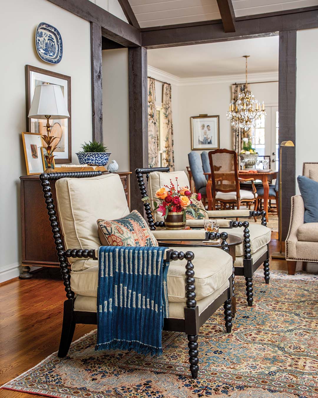 In the living room, neutral upholstery enhances the warmer tones in the rug while layers of blue and brown accents solidify the scheme for a soothing and welcoming aesthetic.