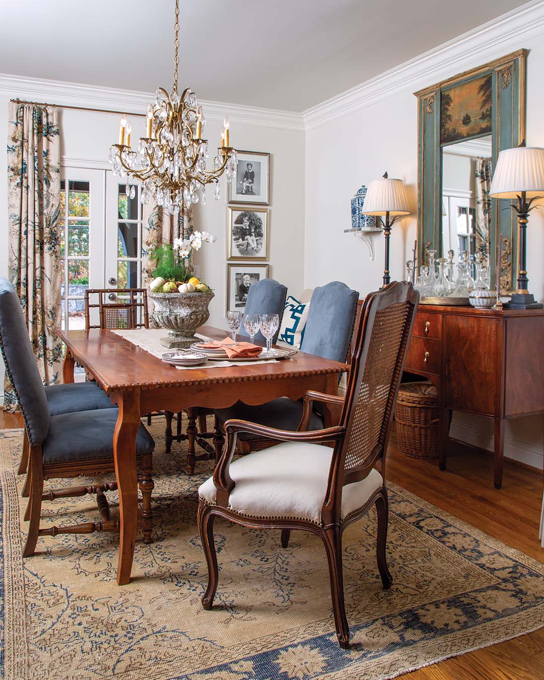 In the dining room, a striking antique trumeau mirror, complete with the original painting, serves as the inspiration for the surrounding scene.