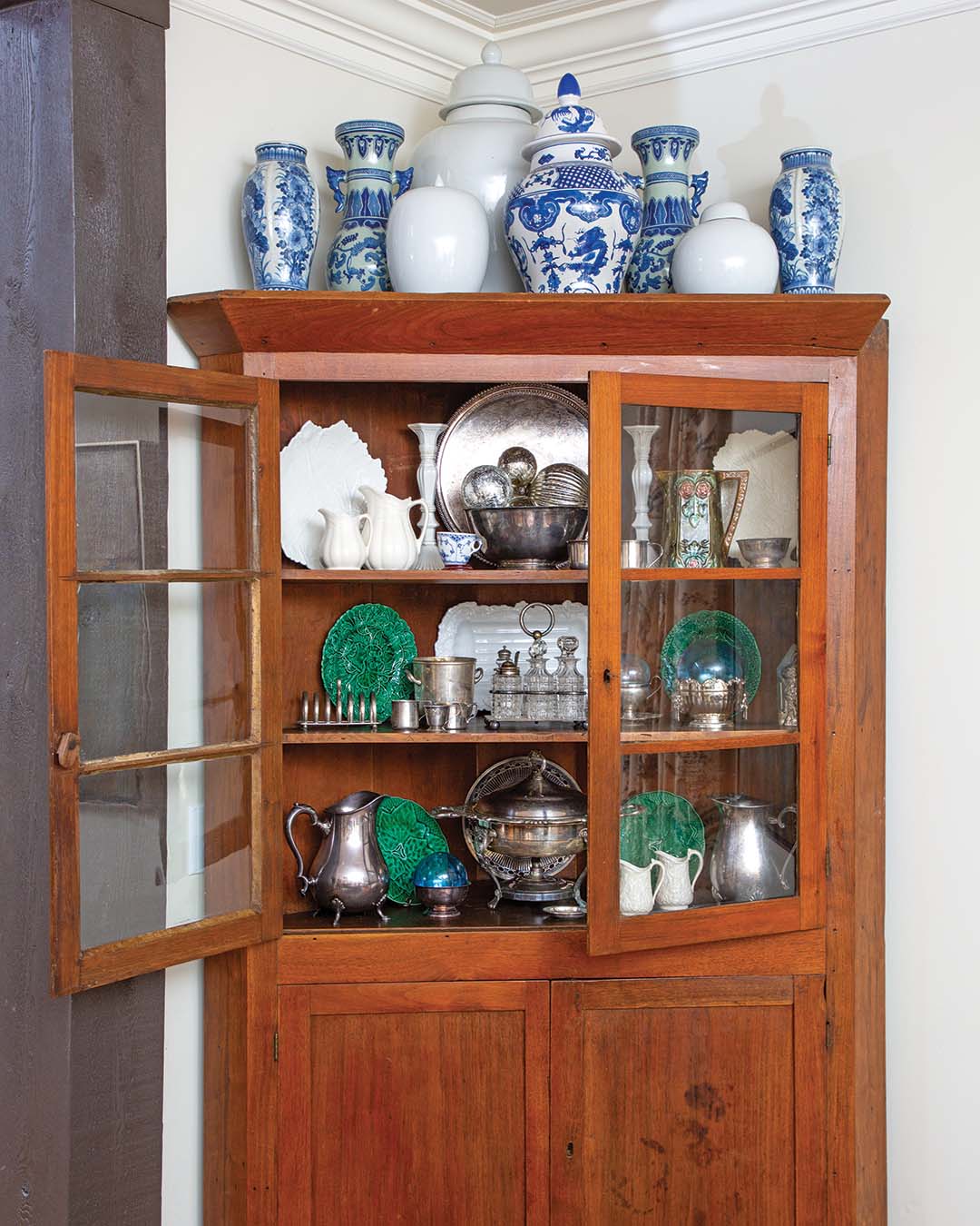 The hutch—a family heirloom of Robert’s—houses their various collections, which span from sterling silver to majolica.