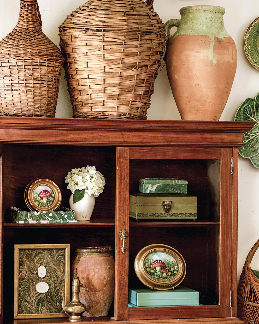 Paintings from CE Fine Art Studio. Large terra-cotta amphora from etúHOME. Framed cameos and marbled scalloped tray from Cuvée Home.