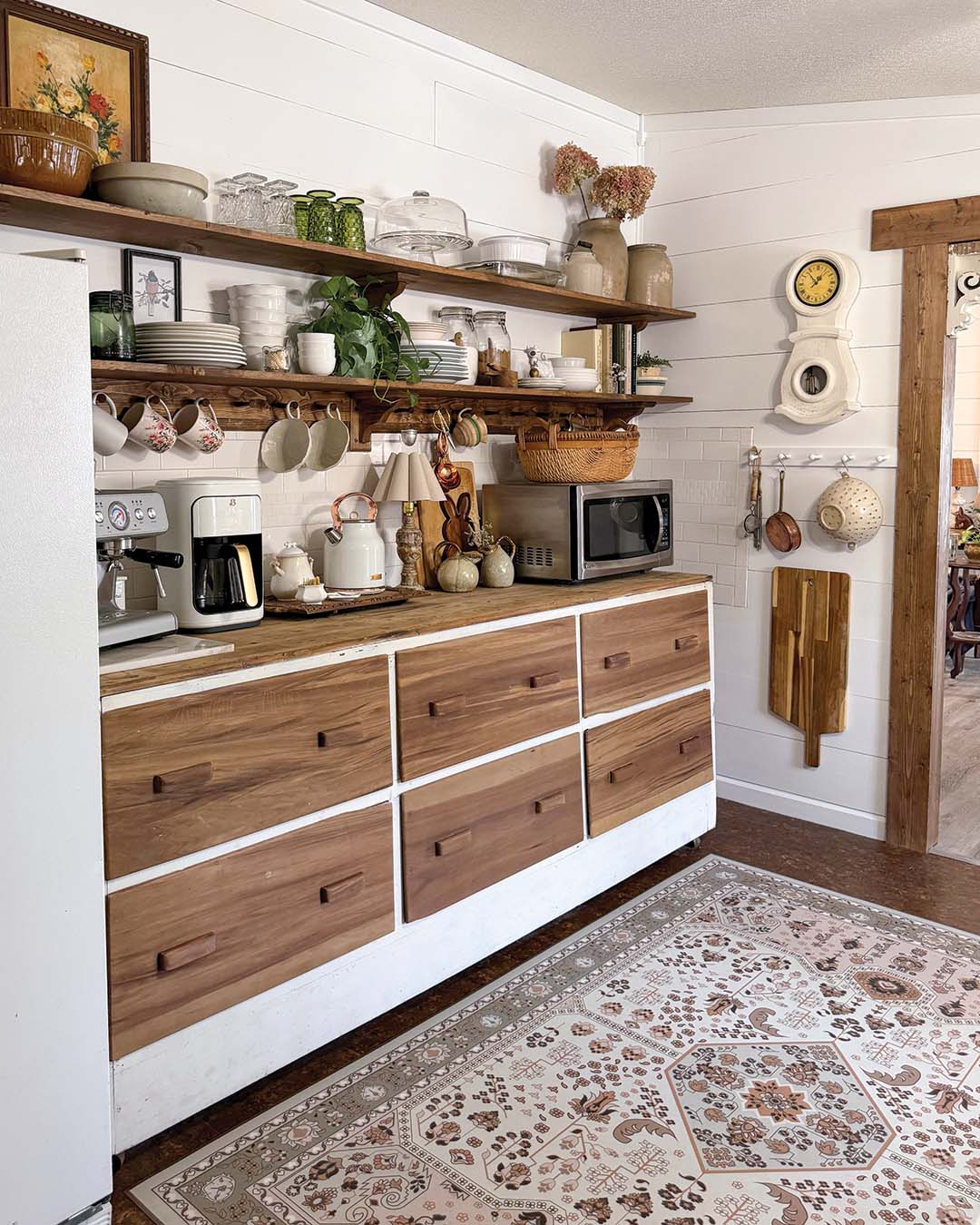 Kassie put her DIY skills to use in the kitchen, replacing the upper closed cabinets along one wall with a pair of wooden shelves. “I want functionality, so everything that’s on my open shelves is stuff I use every day,” says Kassie. The dresser below was given a new lease on life, as she stripped the paint from the six drawers to reveal the natural wood beneath. The now two-toned piece fits perfectly within the design scheme of her home.