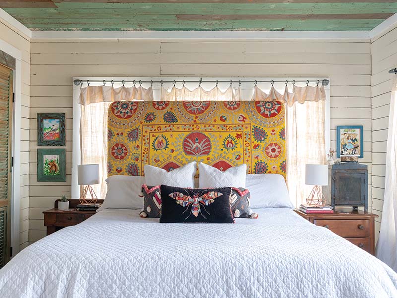 In the primary bedroom, a headboard made of an antique suzani injects the room with vibrant personality. “To me, it’s the color and the texture of the piece,” Meredith says. “It’s a piece of art.”