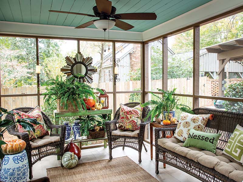 Just off the dining room, the screened-in porch serves as a charming spot for after-dinner drinks. A haint-blue ceiling and a collection of potted plants create the effect of being outdoors while the wicker furniture is protected from the weather, helping Beth and Buddy enjoy the space rain or shine.