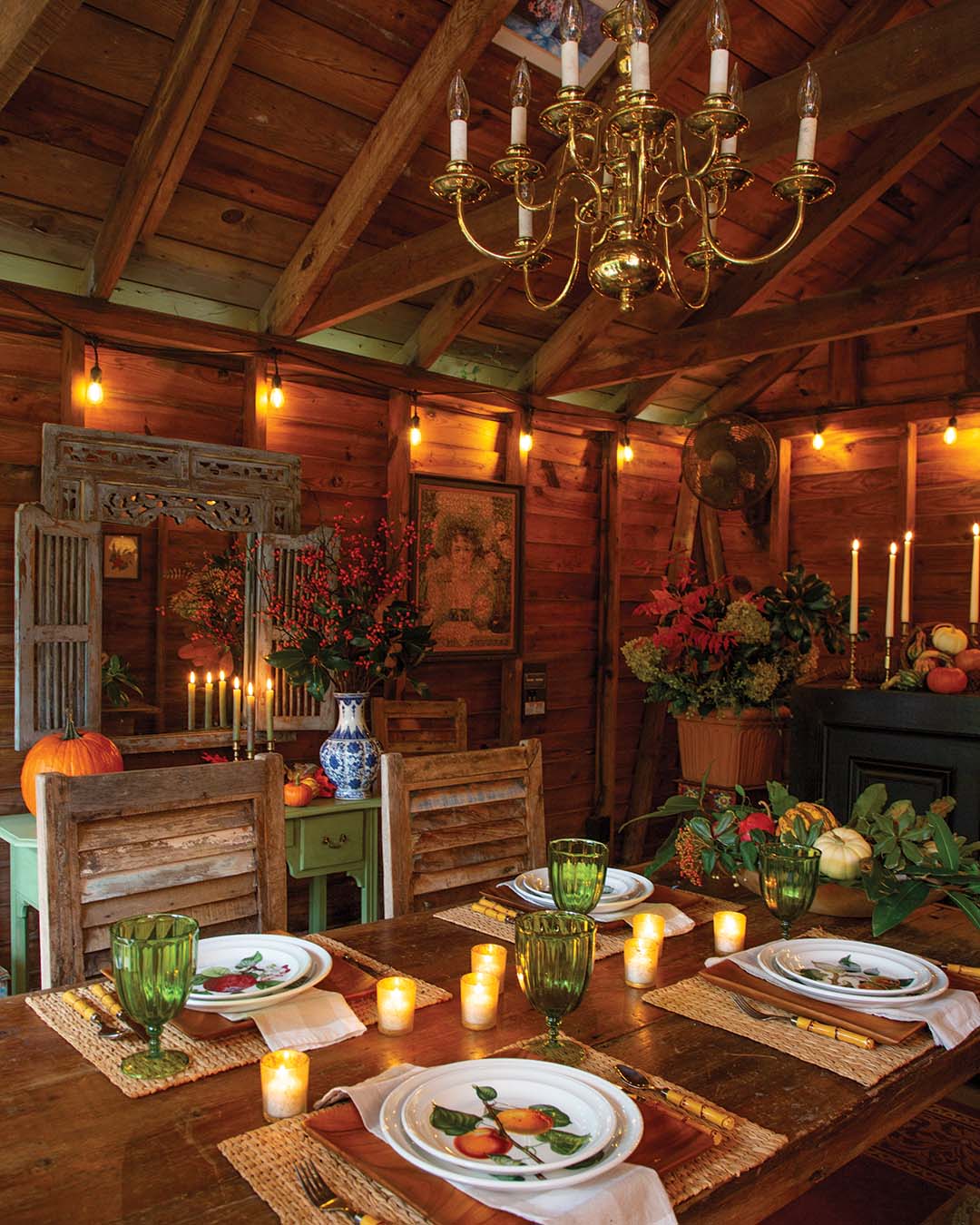 Weathered hand-me-down chairs from Beth’s daughter and a farmhouse-style table seat up to six, and a stand-alone furniture piece serves as a makeshift bar. Enhancing the cozy atmosphere, stacks of multicolored pumpkins and fall florals layer every surface in the space.