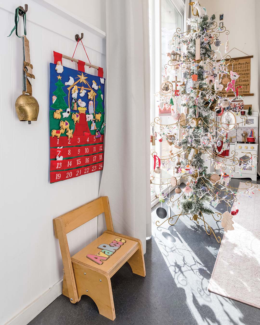 In contrast to her usual approach, Annette gravitates to more traditional décor when decorating her daughter’s room for a more playful atmosphere. A vibrant felt Advent calendar adds a touch of classic Christmas cheer, while a delicate wire-framed tree serves as the centerpiece. Adorned with an array of whimsical ornaments and sprinkled with frosted greenery, the tree evokes the magic of a winter wonderland while making the space festive for the youngest family member to enjoy.