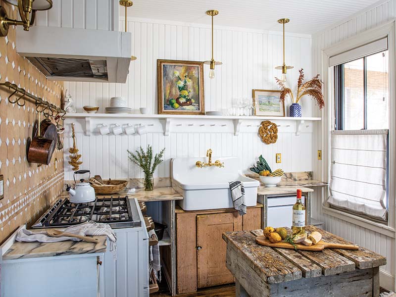 “I love the mix of high and low—like a really pretty gilded mirror with a textural, primitive worker’s table,” Anthony says, pointing out pieces like the worn table that serves as an island in the kitchen. In place of traditional cabinetry, the team built under-counter storage spaces, which were supplemented by a vintage unit to the left of the range and a Shaker-style cupboard turned sink base that dates back to the mid-1700s.