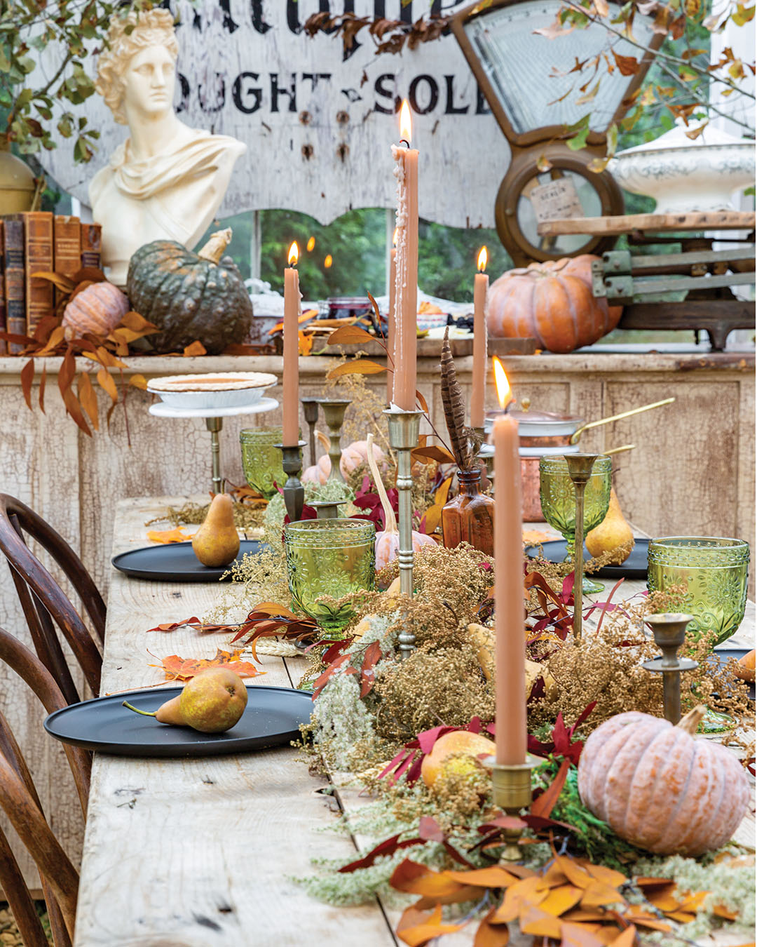 Complementing dishware and taper candles in dramatic tones—a favorite tendency of Ashley’s—the runner finds texture and color in both fresh and dried elements, including bold splashes in the form of burgundy and gold eucalyptus. “I love a moody table setting,” says Ashley, who filled in with pears, amber bottles, feathers, and moss tucked beneath pumpkins for an effect that any 19th-century naturalist would love.