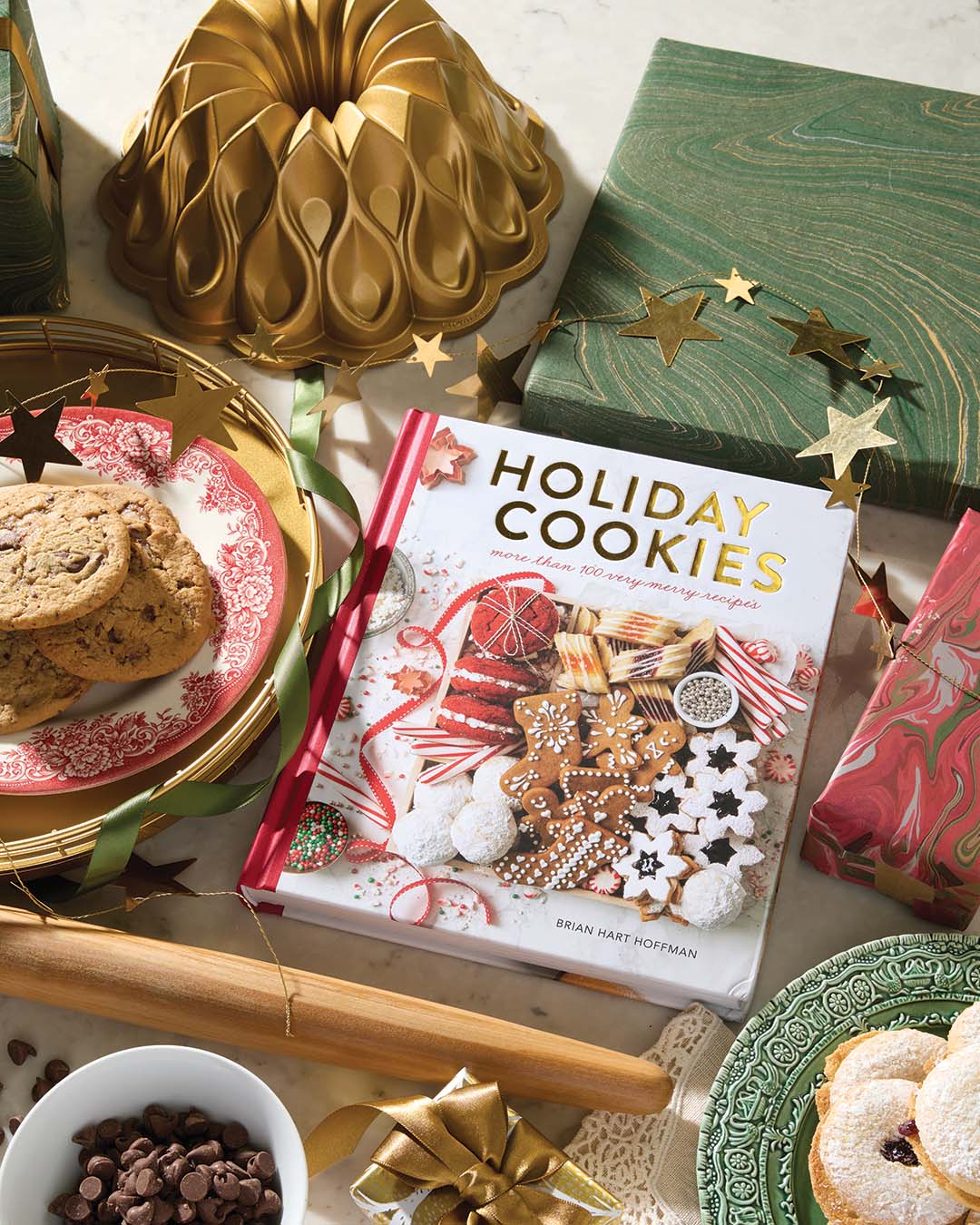 Holiday Cookies cookbook and Bundt pan from Hoffman Media. Brass star garland from Roan Iris. Green plate from Arte Italica. Johnson Brothers Old Britain Castles Pink Christmas plate from Replacements, LTD.