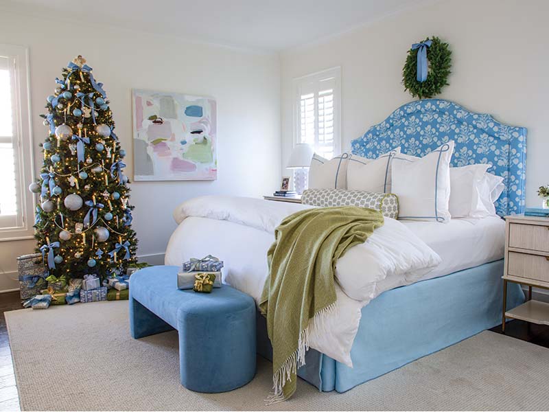 The primary suite’s palette started with the headboard’s Lulie Wallace fabric. Kate carried its blue hue into the bath with a chinoiserie wallpaper by Thibaut and artwork she created herself.