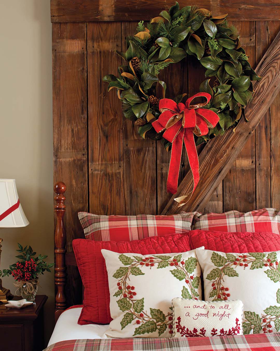 Ready a cozy bedroom for beloved guests with a wreath displayed on a rustic headboard, reflecting the embroidered circlets gracing a duo of seasonal pillows.