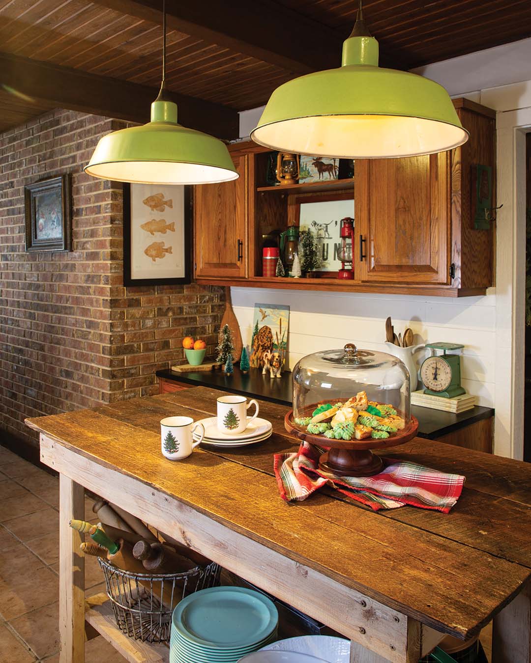 The kitchen’s brick accent wall, paneled ceiling complete with beams, and wood cabinets contribute to the warmth of the space, emphasized by the makeshift island Stacie found on Facebook Marketplace. The piece is a prime locale during gatherings, as it usually houses the tantalizing spread of appetizers.