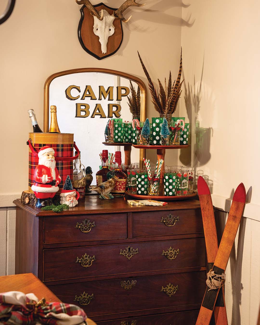 Nestled in a corner, what was once a dresser becomes a stylish bar, thanks to the personalized mirror and two-tiered stand displaying vintage glassware.