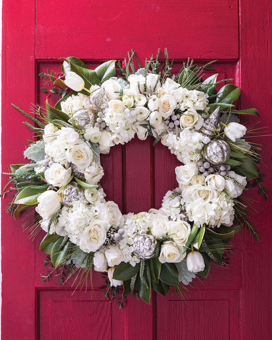 Pristine white roses, ranunculus, hydrangeas, and tulips layered with dusty miller, silver brunia, and assorted evergreens bring to mind a true white Christmas.