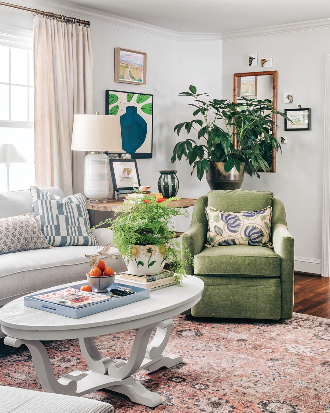 Artwork plays a big role throughout this home and makes a statement in the living area. “We had a lot of fun collecting art—for this room especially,” Amanda Louise says. “We were able to pull in art from artists we have loved for years and years while also pulling in a new-to-us artist in Haley Hughes with the large pieces in the green frames.”