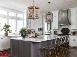 Tour a Transitional Home Layered with Mid-Century Style & Antique Finds Meg pulled from the whitewashed wood of the lanterns when selecting the woven and wood accessories dotted about the space. An antique tole tray draws the eye to the range as it lends a dark contrast to the marble tile backsplash.