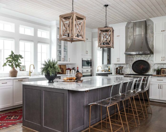 Meg pulled from the whitewashed wood of the lanterns when selecting the woven and wood accessories dotted about the space. An antique tole tray draws the eye to the range as it lends a dark contrast to the marble tile backsplash.