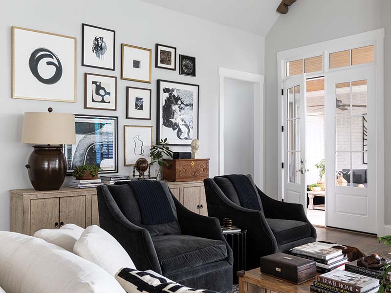 Covered in a charcoal velvet, the swivel chairs elevate the space while complementing the artwork displayed on the gallery wall.