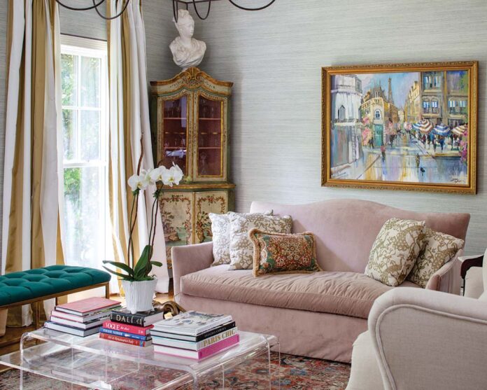 Velvet sofas and acrylic tables pair perfectly with an antique painted hutch in the living room.