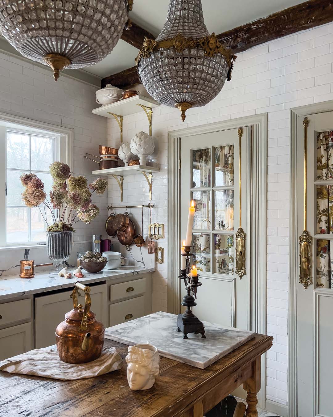From the basket chandeliers and island to the fabric backing the French doors, the kitchen boasts just as many beautiful found treasures as the rest of the home.