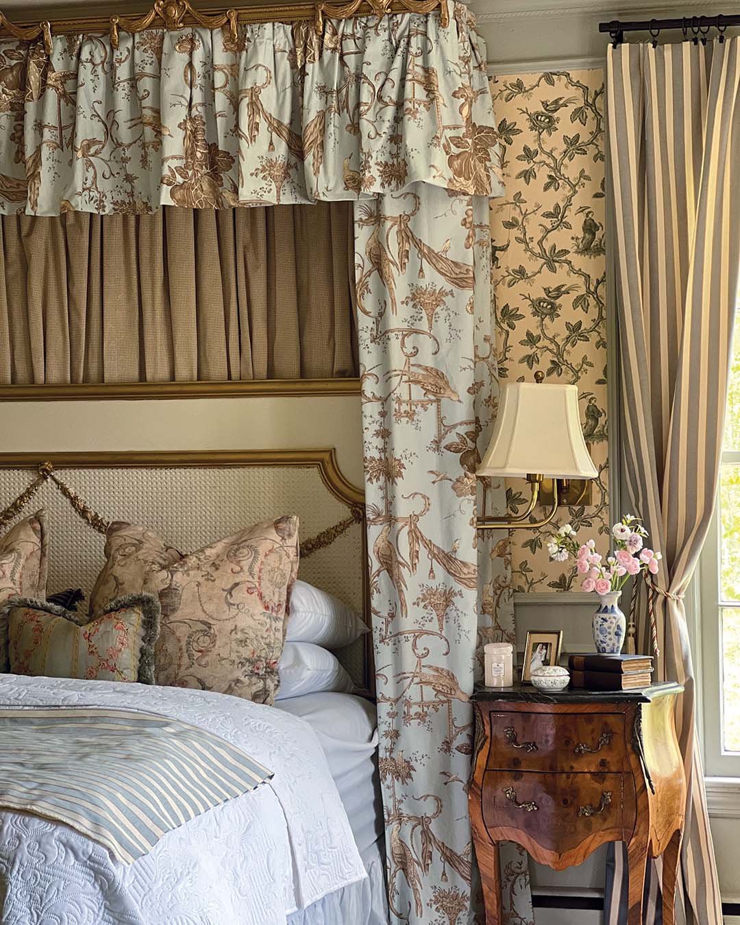 Despite the collected look of the primary bedroom, Paige only recently pulled the space together following the discovery of a discontinued Colefax and Fowler wallpaper on Facebook Marketplace—the same place she found the custom rug. Curtain panels she’d been holding on to found new life as a bed canopy, and finishing touches like ceiling embellishments and a painted armoire pulled everything together.